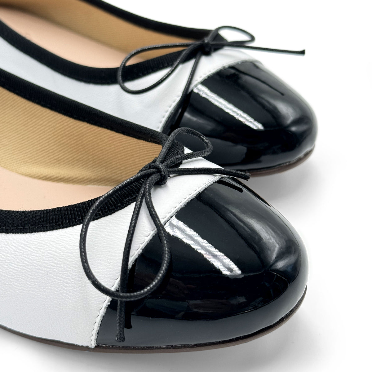Ballerines en cuir blanc avec bout verni noir