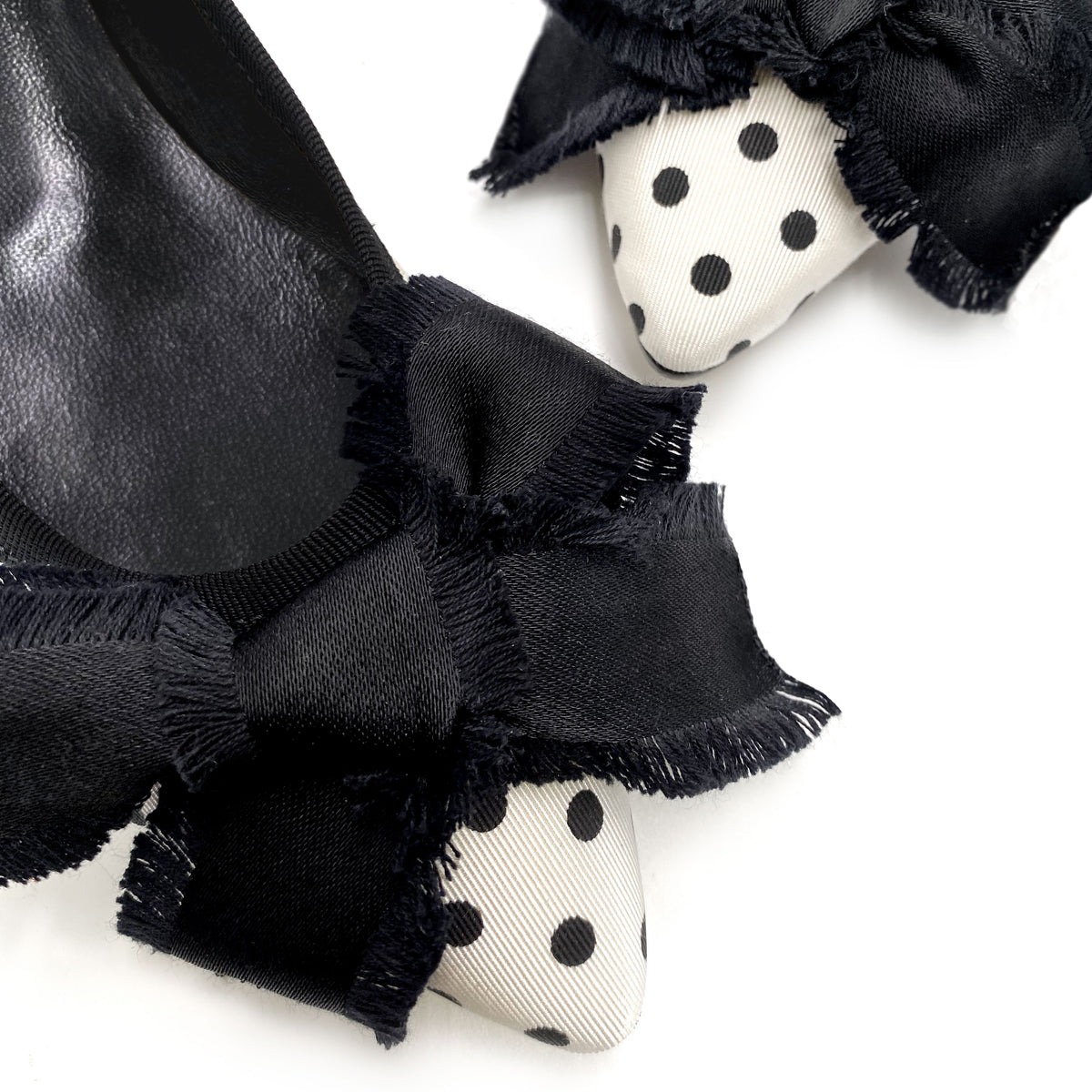 Ballerinas mit spitzer Spitze aus schwarz-weiß gepunktetem Stoff mit Schleife