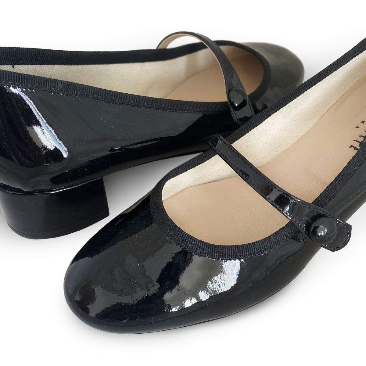 Black patent leather ballet flats with strap and heel